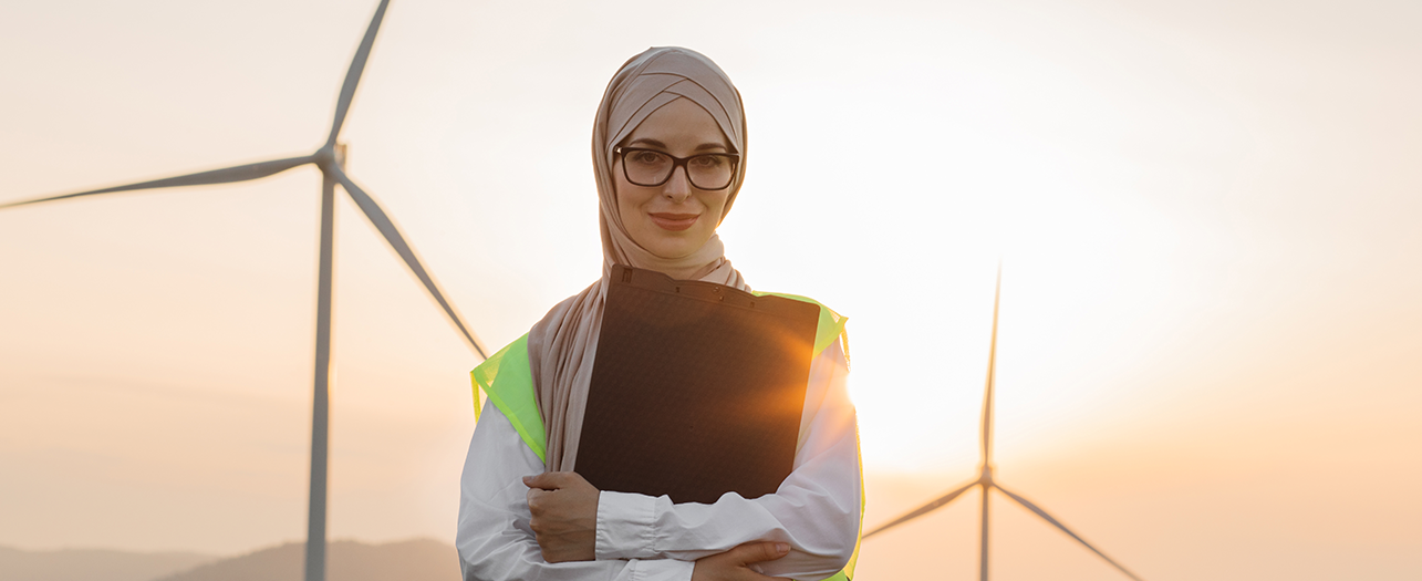 Woman standing near wind turbines at a renewable energy site Woman standing near wind turbines at a renewable energy site